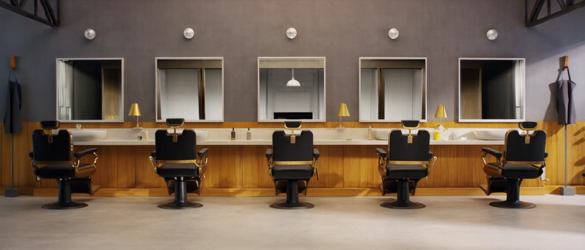 The Bartwerk fit-out before opening: six identical barber chairs facing a continuous mirror wall under brass lamps