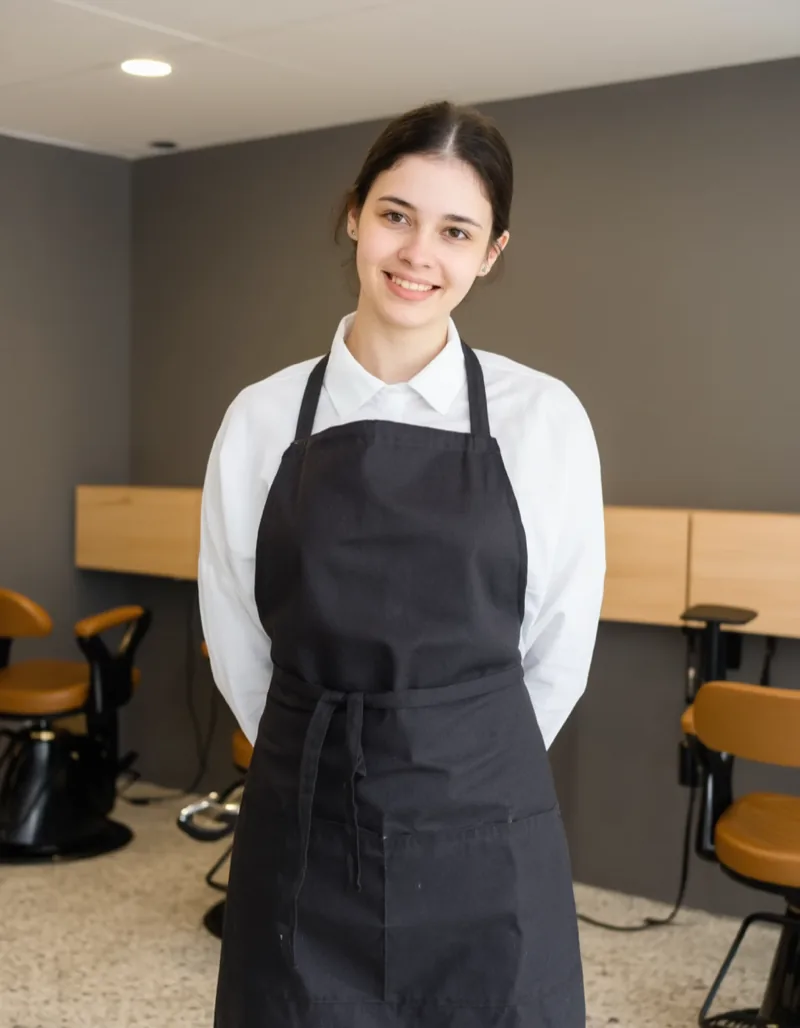 Selin Aydın in the Bartwerk apron in front of the shop mirror wall